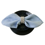 Chapeau noir orné d'un ruban bleu clair avec une rangée de perles.