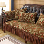 Le canapé en cuir brun avec des coussins et une housse à motifs floraux crée une ambiance chaleureuse et élégante dans cette pièce.