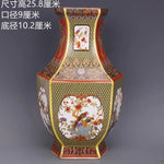 Cette œuvre d'art est un vase décoratif de style oriental, orné de motifs floraux et d'oiseaux colorés sur un fond jaune et rouge. Ses dimensions imposantes et sa conception détaillée en font une pièce d'exception.