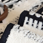 Gros plan de la texture douce et moelleuse d'un tapis ou coussin blanc et noir.