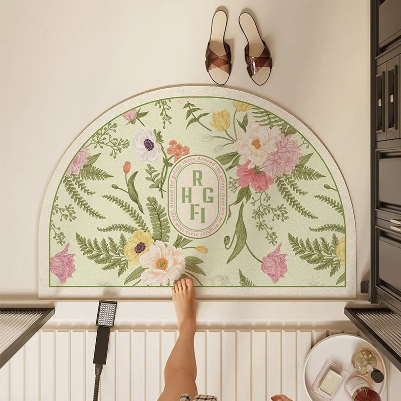 Tapis décoratif en demi-lune avec un motif floral coloré et le monogramme "RHGFI" au centre, entouré de feuilles et de fleurs.