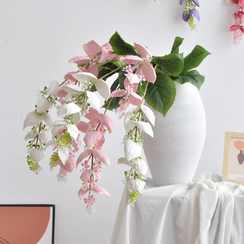 branche artificielle fleurs naturelles extérieur accrochées blanc vert feuilles larges minimaliste