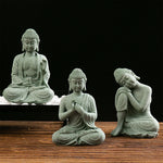 statuette bouddha assise gris vert texture pierre zen minimaliste abstraite galets mousse plateau noirscriçãopta
