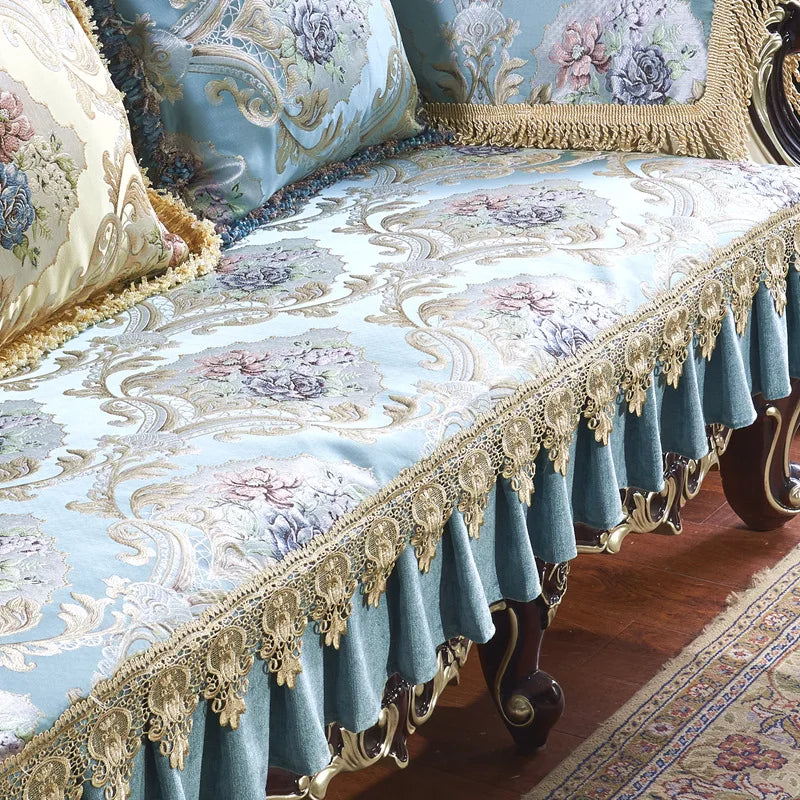 Un magnifique ensemble de literie avec un design floral et une bordure dorée ornementée, créant une atmosphère chaleureuse et luxueuse dans la chambre.