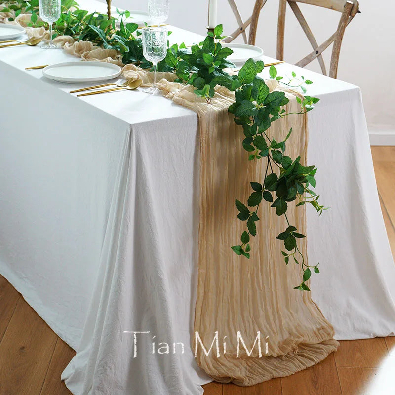 La table est joliment décorée avec des feuilles vertes et une nappe blanche, créant une ambiance apaisante et naturelle.