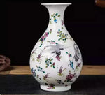 Vase en porcelaine blanc orné de fleurs colorées et d'oiseaux.