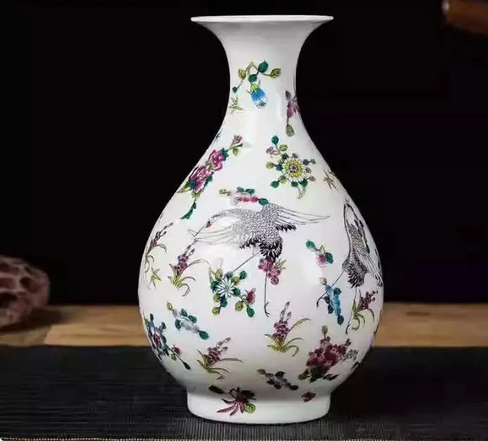 Vase en porcelaine blanc orné de fleurs colorées et d'oiseaux.