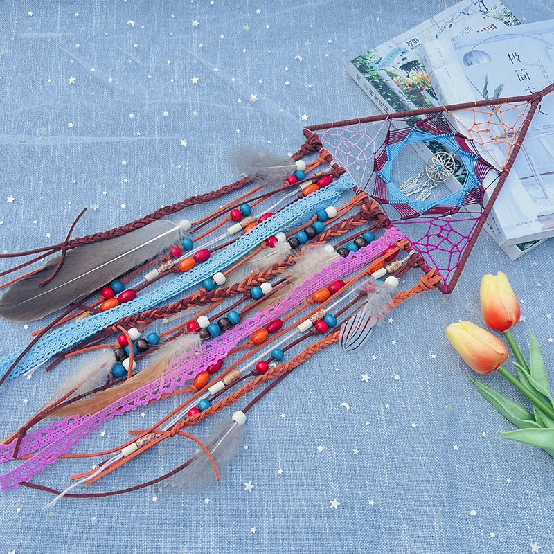 Une composition artisanale colorée de perles, de plumes et de rubans sur fond bleu étoilé.