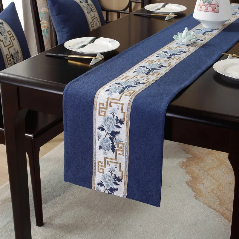 La magnifique table drapée d'un chemin de table bleu marine orné de motifs floraux et géométriques élégants, offrant un décor sophistiqué pour une réception ou un dîner.