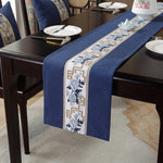 La magnifique table drapée d'un chemin de table bleu marine orné de motifs floraux et géométriques élégants, offrant un décor sophistiqué pour une réception ou un dîner.