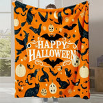 Une couverture ou un plaid Halloween orange orné de chats noirs, de chauves-souris et de citrouilles.