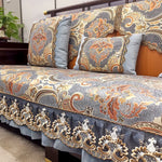 Couvre-lit élégant et détaillé, présentant un motif floral et cachemire dans des teintes gris, orange et blanc, avec des touches de couleurs vives et un look sophistiqué.
