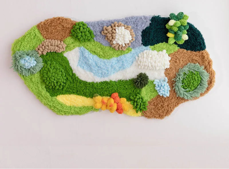 Une œuvre d'art textile colorée et texturée, représentant une scène de paysage naturel avec des fleurs et des roches.