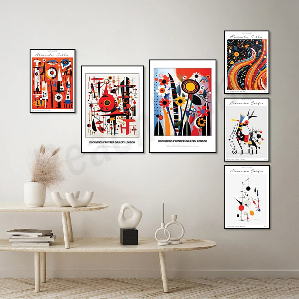 Ensemble d'affiches colorées et abstraites d'art contemporain, exposées sur un mur blanc avec une table basse en bois et des objets décoratifs.