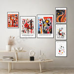 Ensemble d'affiches colorées et abstraites d'art contemporain, exposées sur un mur blanc avec une table basse en bois et des objets décoratifs.