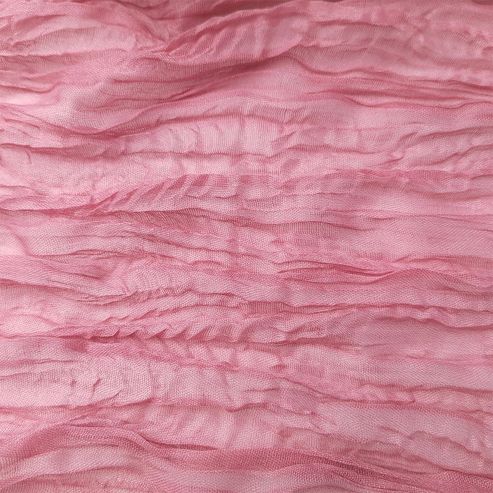 Texture plissée rose brillante avec des plis et des reflets lumineux.
