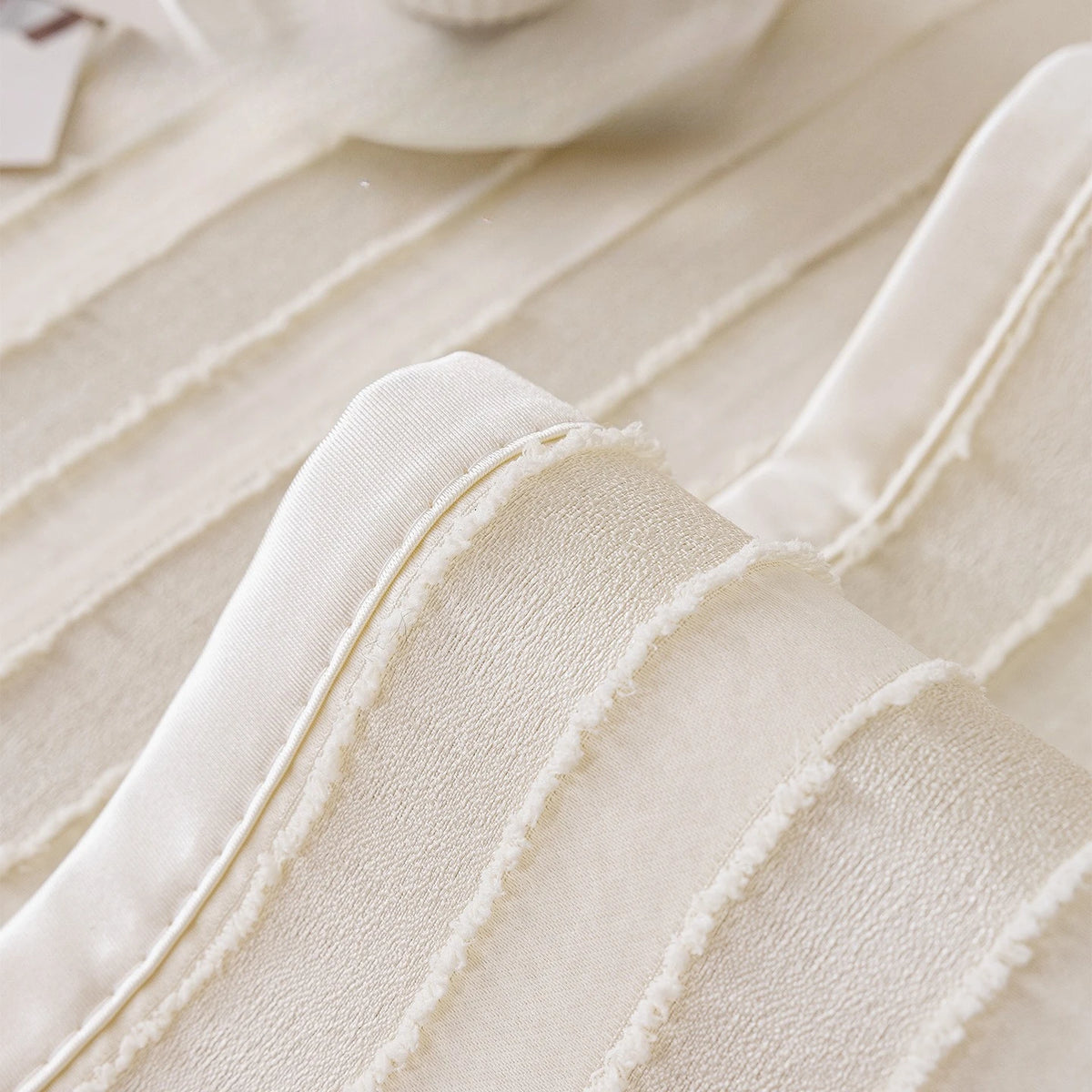 Des éléments de tissus beige et blanc texturés créant un motif organique et élégant.