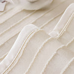 Des éléments de tissus beige et blanc texturés créant un motif organique et élégant.