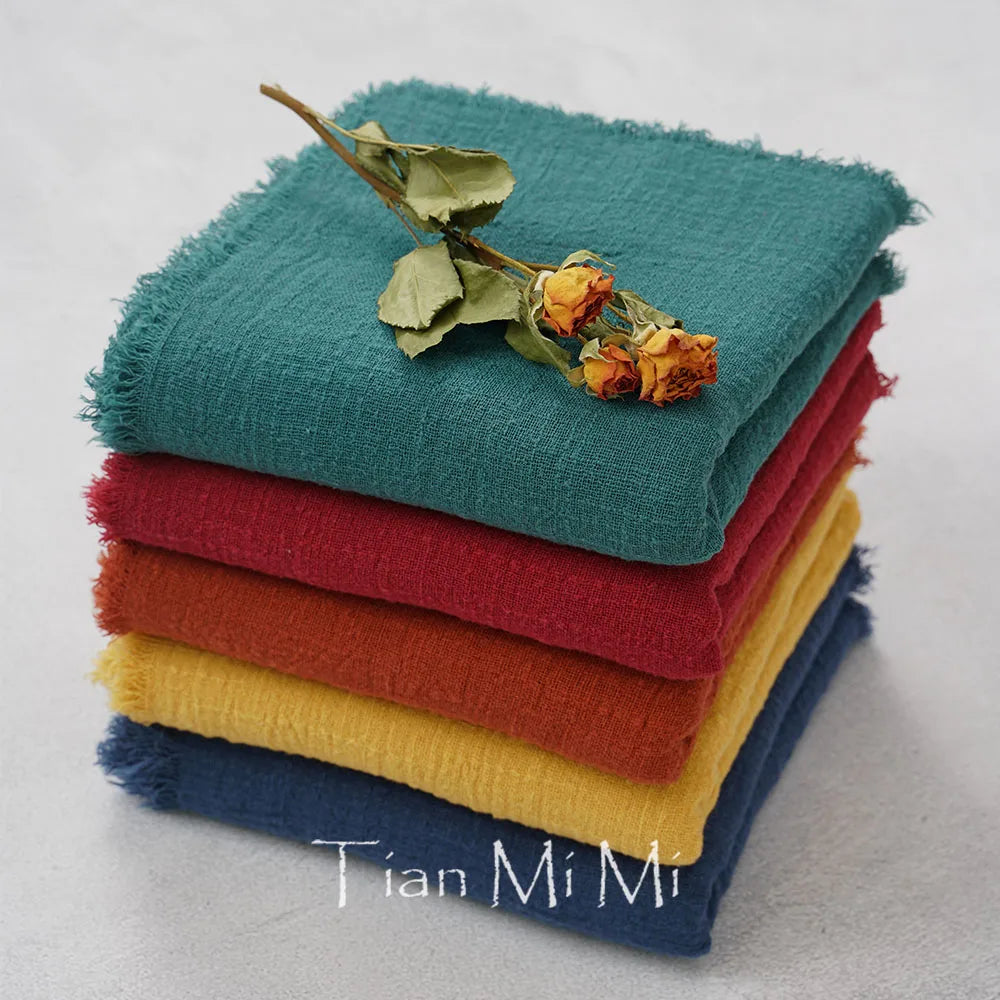 Une pile de serviettes de couleurs vives, avec une fleur séchée posée sur le dessus, une image de beauté et de tranquillité.