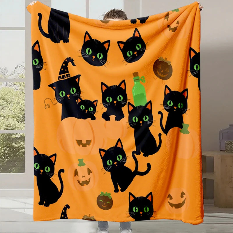 Couverture de décoration d'Halloween avec des motifs de chats noirs et de citrouilles sur un fond orange.
