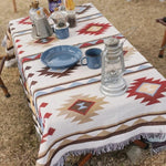 Plaid indien rayé noir et vert plié sur canapé
