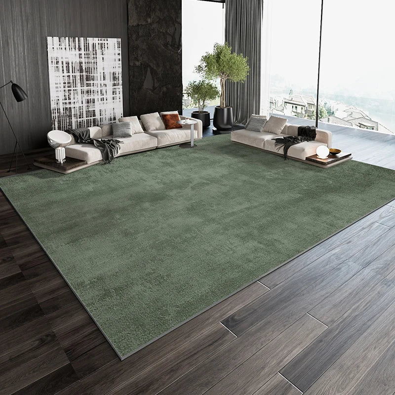 Un intérieur moderne et épuré avec de grands canapés moelleux sur un tapis vert foncé, face à de grandes fenêtres offrant une vue sur l'extérieur.
