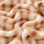 Une couverture moelleuse et confortable, avec des textures douces et accueillantes, parfaite pour se lover et se détendre.