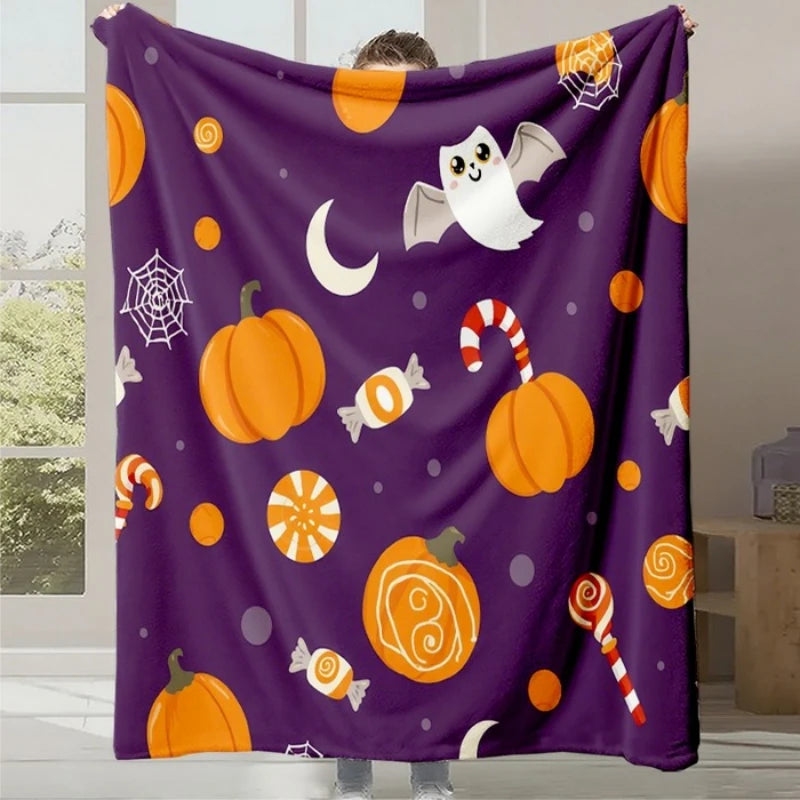 Couverture en laine polaire violette avec des motifs d'Halloween, incluant des citrouilles, des fantômes, des bonbons et des toiles d'araignée.