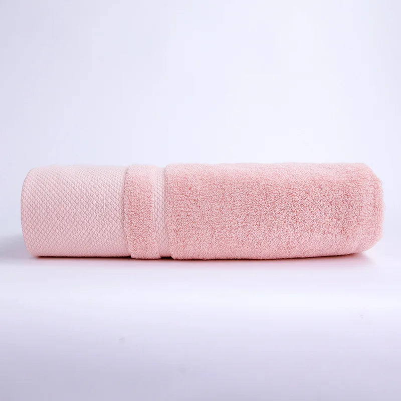 Serviette de bain en coton rose pâle, douce et absorbante.