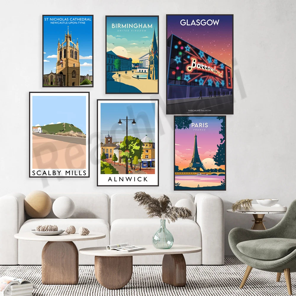 L'image présente une collection d'affiches de voyage illustrant des lieux célèbres tels que la cathédrale St Nicholas à Newcastle, la ville de Birmingham, Glasgow avec son parc d'attractions Barrowland, le village de Scalby Mills et la ville d'Alnwick, ainsi que la ville de Paris et sa tour Eiffel. Ces affiches sont disposées sur un mur blanc, encadrant un salon moderne avec un canapé blanc, une table basse en bois et un fauteuil gris.