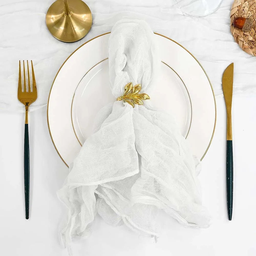 Une élégante table de fête avec des couverts dorés, une serviette blanche ornée d'un élégant embellissement végétal.