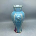 Vase en céramique de forme hexagonale aux nuances de bleu et de violet, décoré de motifs abstraits.