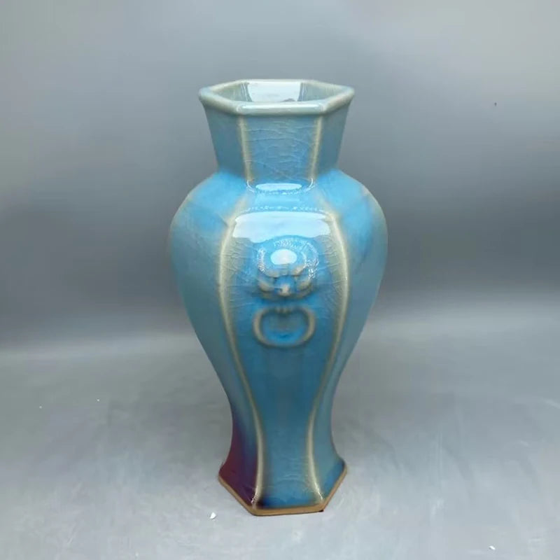 Vase en céramique de forme hexagonale aux nuances de bleu et de violet, décoré de motifs abstraits.