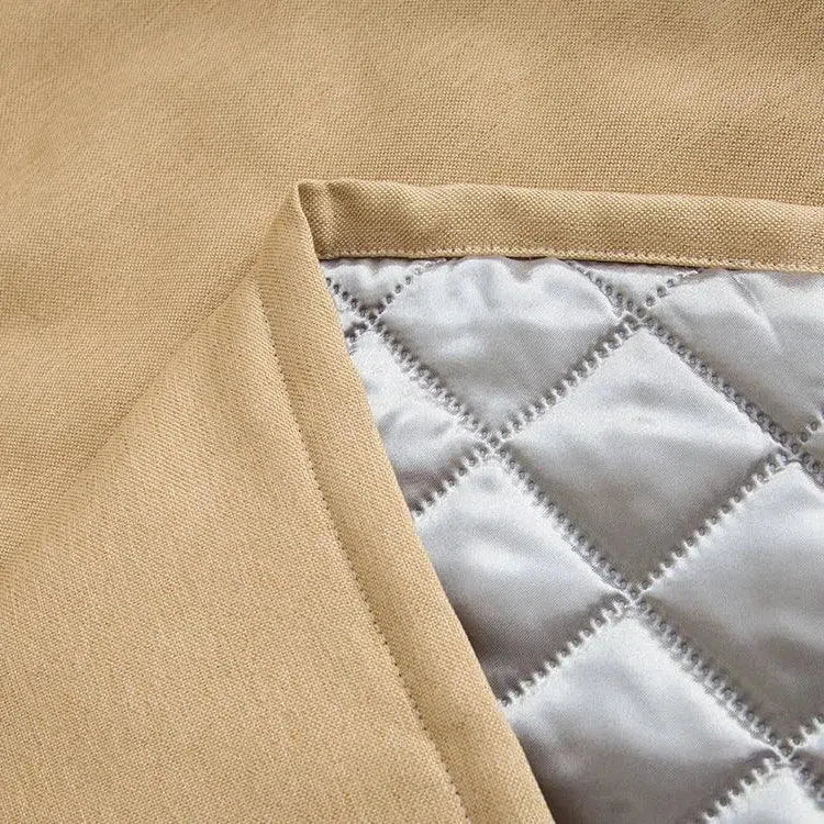 Textile beige avec doublure matelassée en losanges, idéal pour vestes d'hiver modernes, offrant à la fois élégance et confort thermique. Design soigné et finitions de qualité.