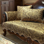 Élégant canapé capitonné avec un motif de damassé doré et brun, placé dans un intérieur classique avec des meubles en bois foncé.