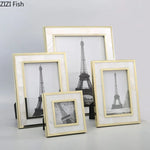 Cadre photo argent coquille créatif métal sur un mur blanc