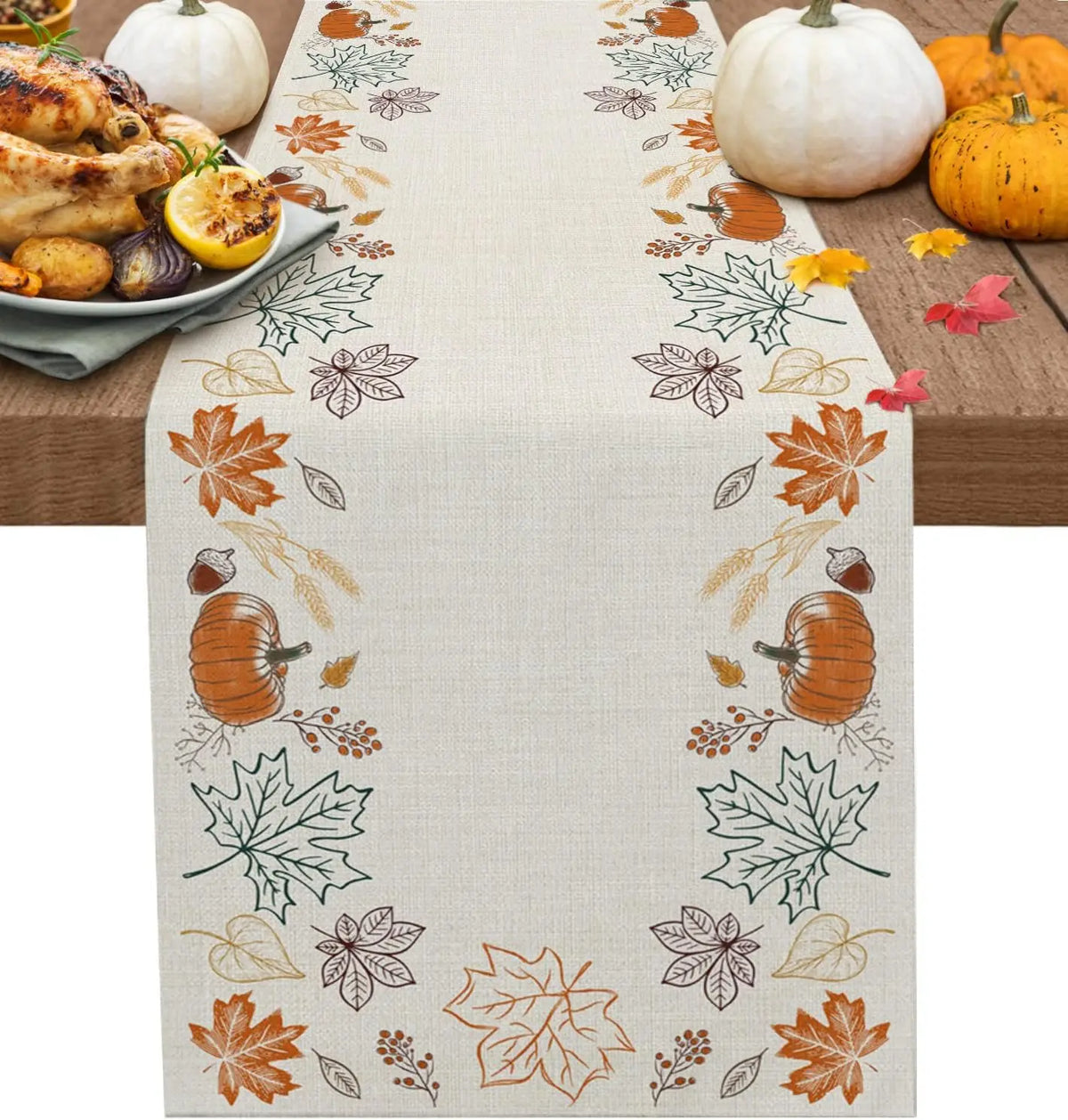 Nappe de table ornée de motifs floraux automnaux, de citrouilles et de feuilles d'érable sur un fond clair, complétée par des légumes et une assiette de poulet rôti, créant une atmosphère chaleureuse et festive pour une table d'automne.