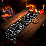 Une table en bois rustique avec des décorations d'Halloween, notamment des citrouilles illuminées, des chandelles et des biscuits effrayants, créant une ambiance festive et mystérieuse.