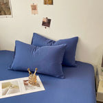 Cette image montre un canapé recouvert de coussins bleus foncés dans un intérieur de style moderne et épuré.