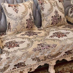 Cette image présente un ensemble de draps de lit et de taies d'oreiller aux motifs floraux ornés de volutes et d'ornements dans les teintes de beige, de marron et de doré, donnant un aspect luxueux et raffiné à la chambre.