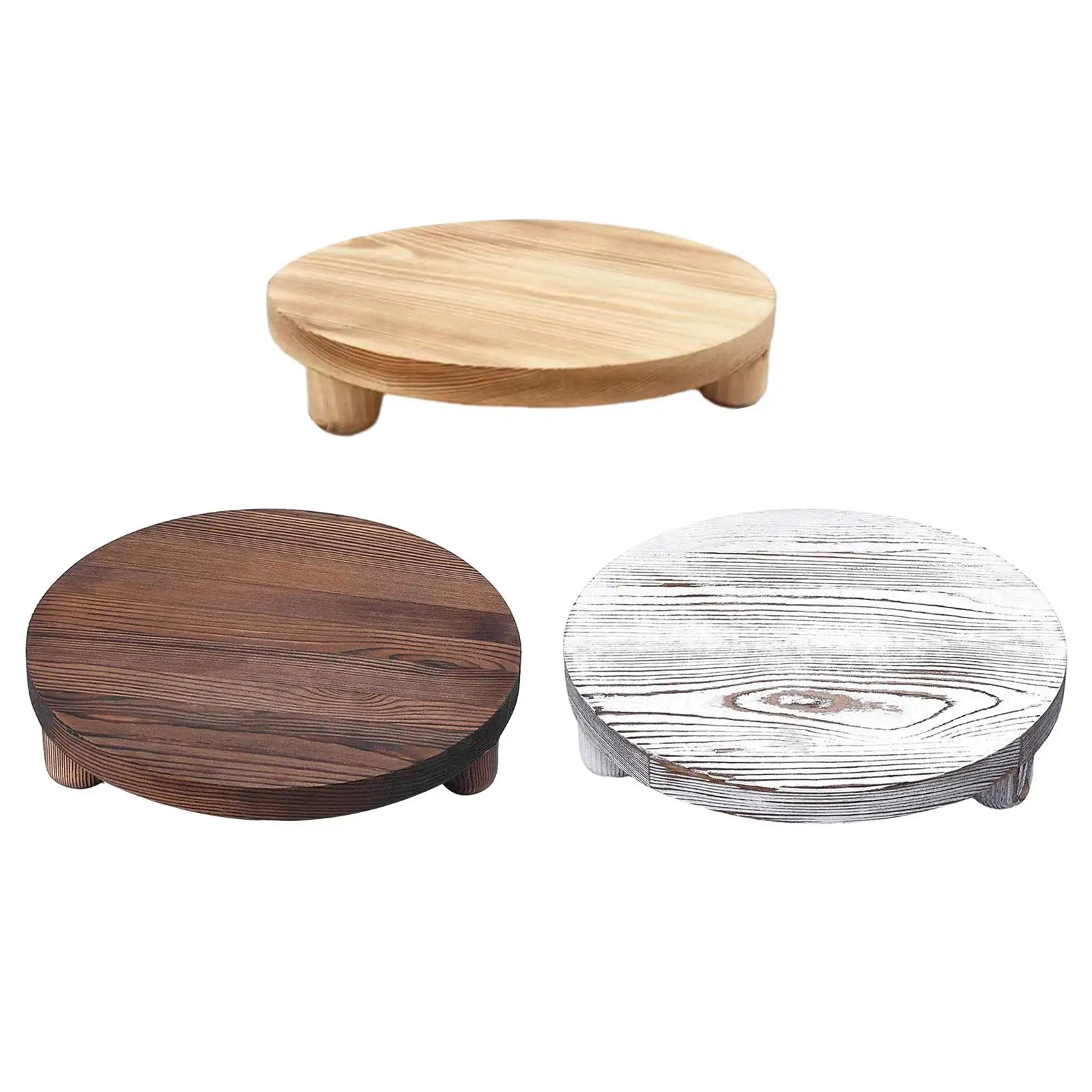 Plateau sur pied en bois brut rond dans une salle de bains avec des accessoires
