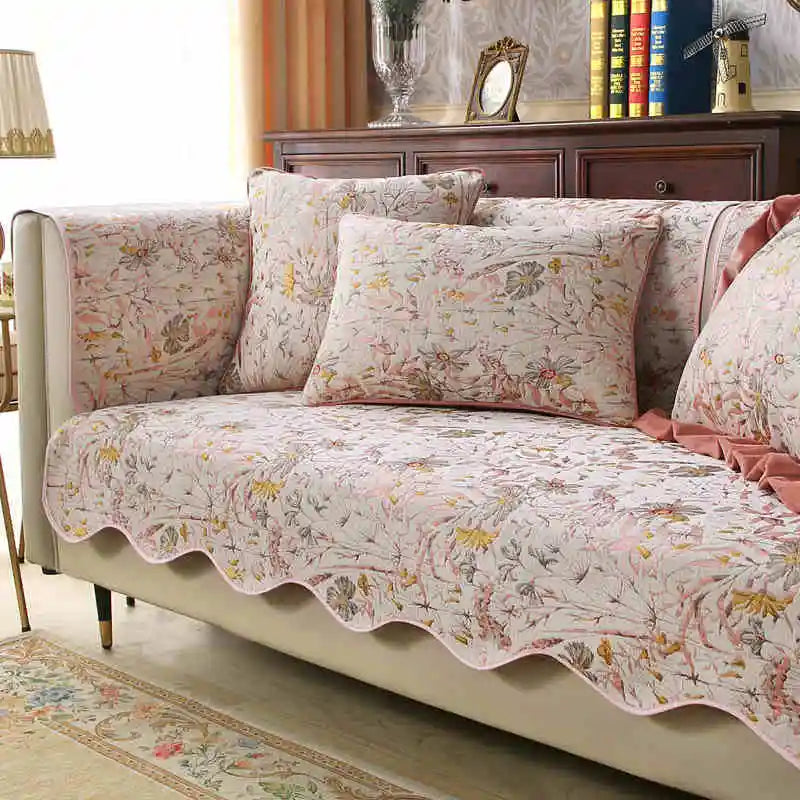 Un canapé confortable aux tons pastel avec des motifs floraux délicats, offrant une ambiance chaleureuse et élégante dans cette pièce de style vintage.