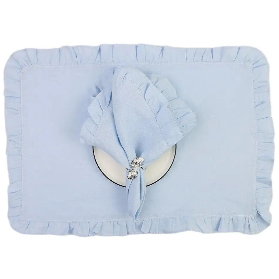 Coussin décoratif bleu ciel avec un motif floral en métal argenté, entouré d'un bord plissé.