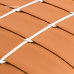 L'image montre une surface en cuir de couleur ocre, avec un motif en damier blanc créé par des liens blancs qui se croisent sur la surface.