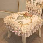 Cette chaise élégante est recouverte d'un coussin décoratif aux motifs floraux et dentelle vintage, offrant une touche de sophistication à l'ameublement.