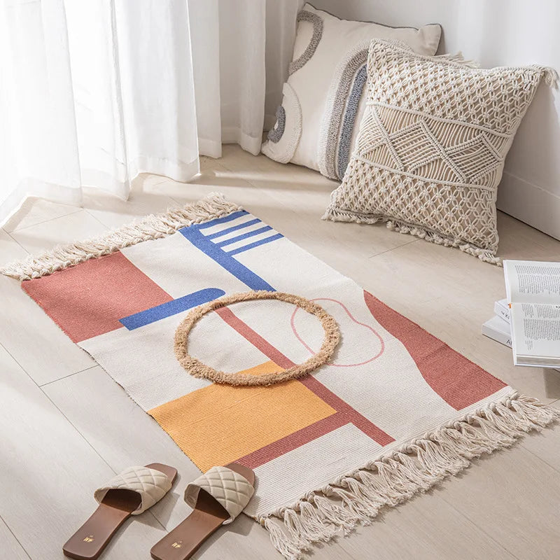 Un tapis coloré avec des motifs géométriques ainsi que des coussins décoratifs sur le sol d'une pièce lumineuse et apaisante.
