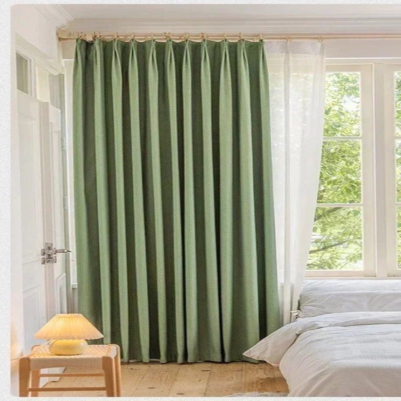 Rideaux verts élégants dans une chambre lumineuse avec fenêtre, apportant une touche de couleur naturelle et un contrôle optimal de la lumière. Design moderne et fonctionnel, parfait pour une décoration intérieure contemporaine.