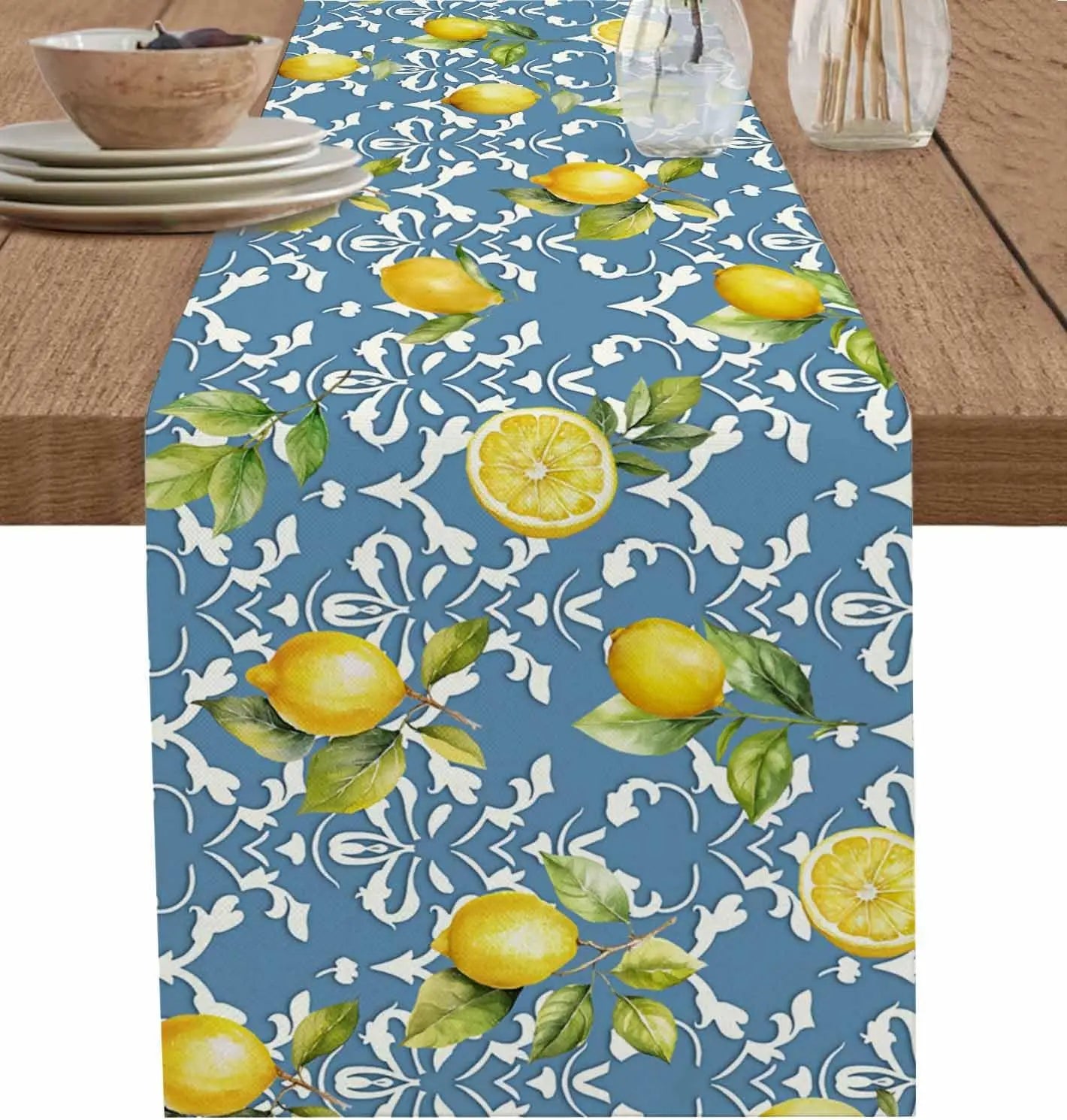 Chemin de table bleu marine avec des citrons jaune vif et des feuilles vertes sur un fond de motifs floraux blancs, créant une atmosphère fraîche et estivale.