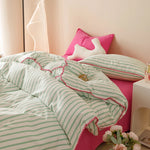 ensemble literie moderne rayé vert blanc rose oreiller rose coussin lapin vase fleurs tapis