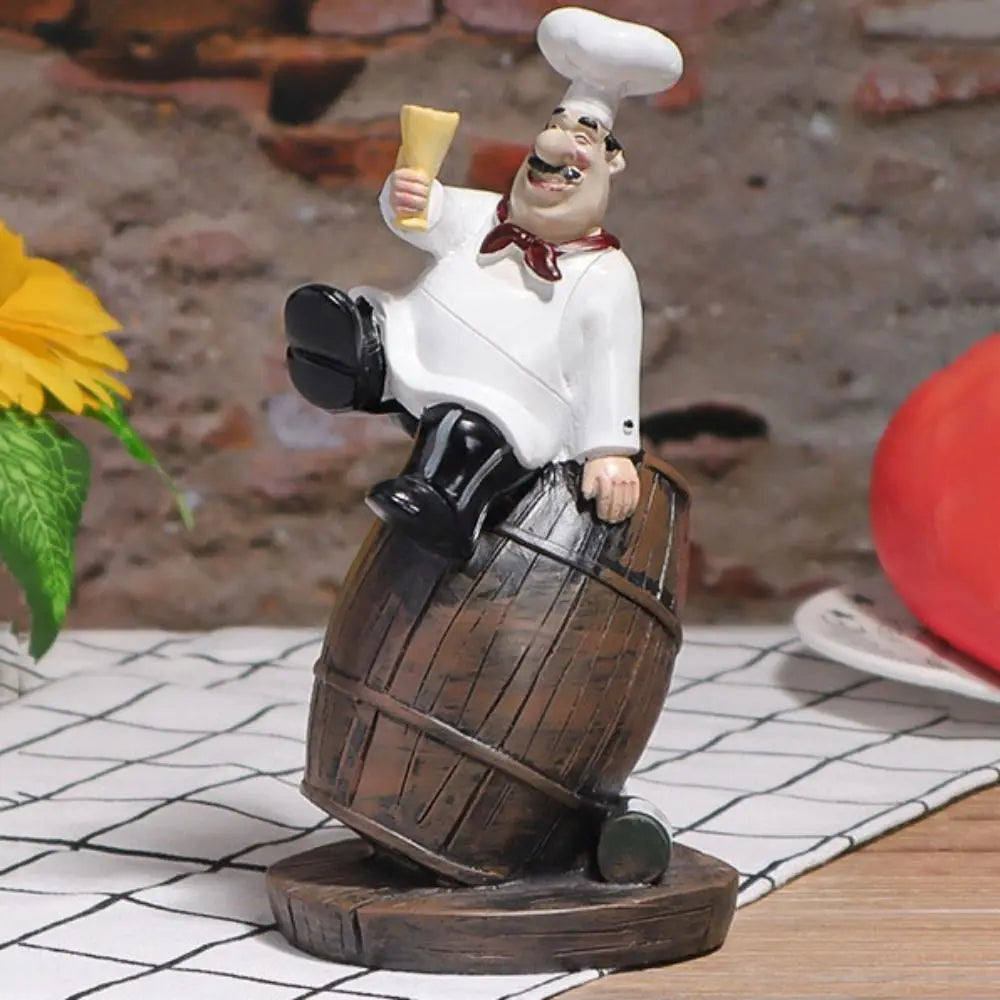 statue cuisinier cartoon uniforme blanc tablier noir chapeau cuillère dorée bouteille pot pomme terre